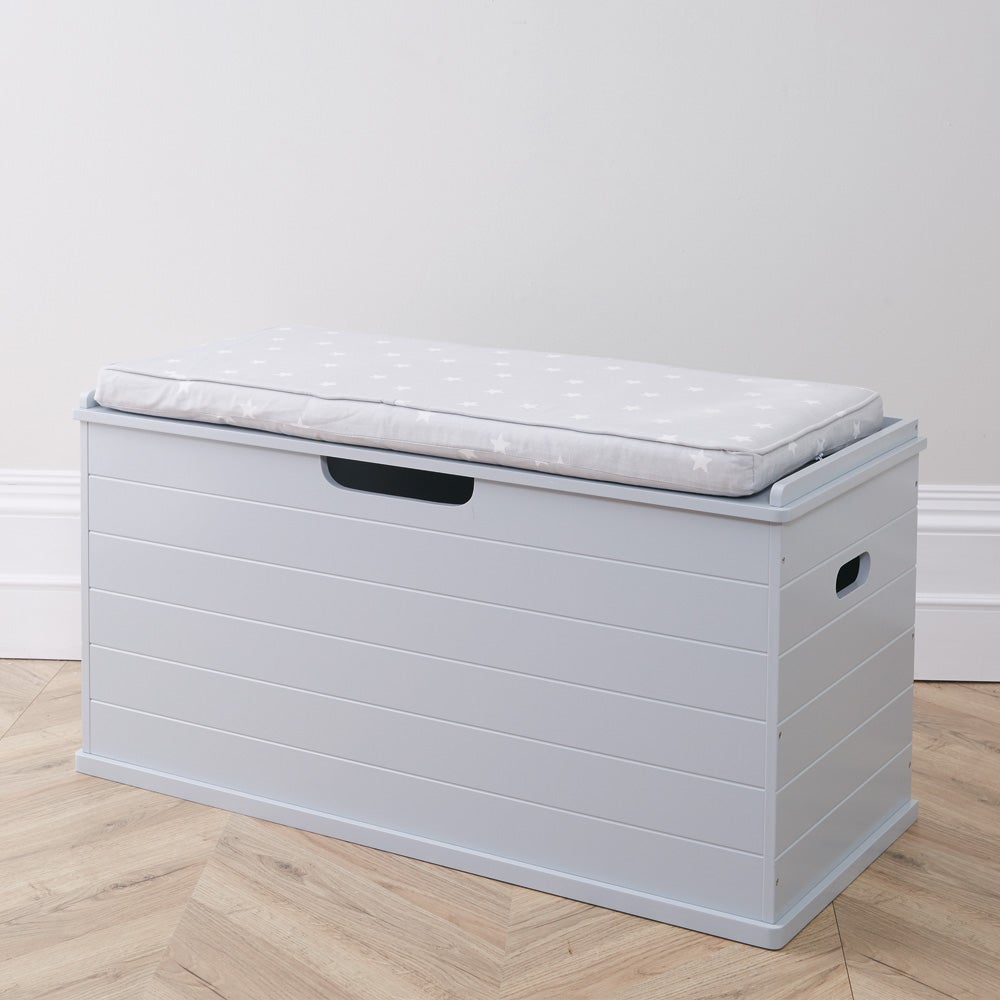 Grey large classic toy box with grey stardust cushion in a room