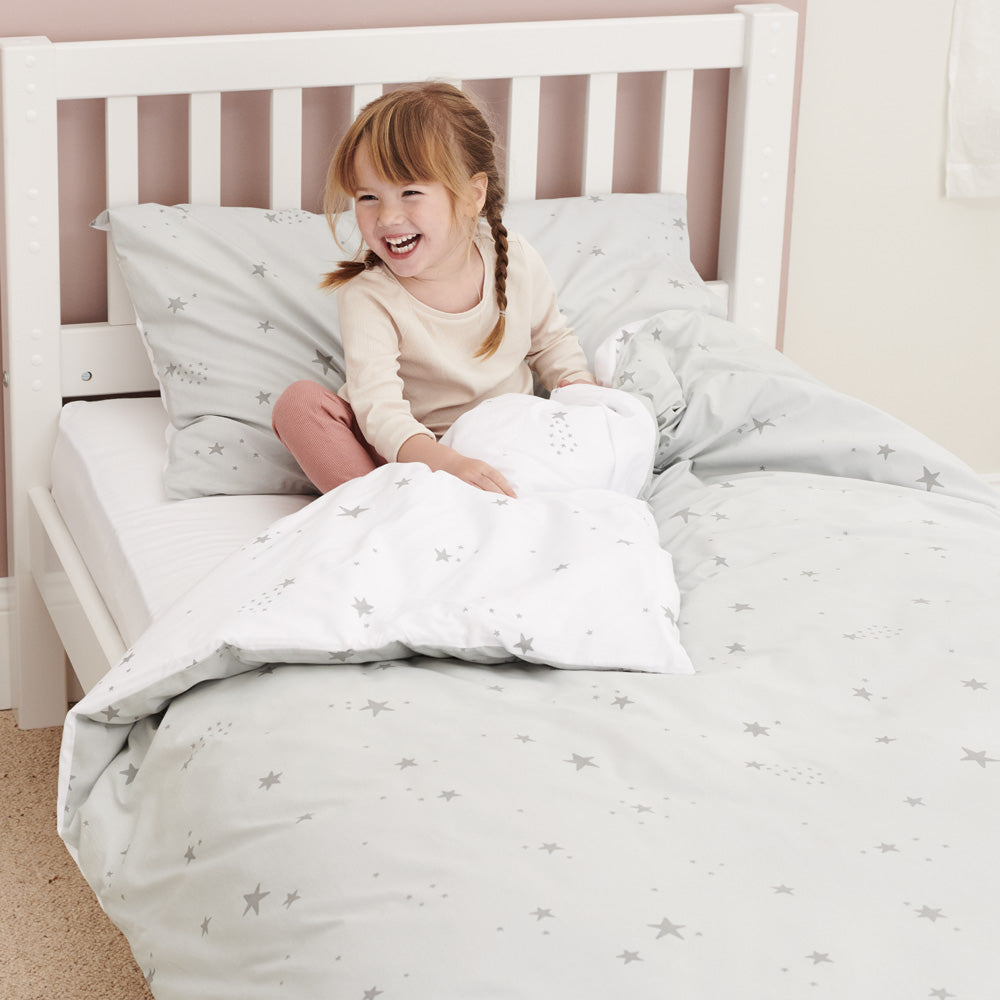 Little girl in bed with grey scattered stars single bedding