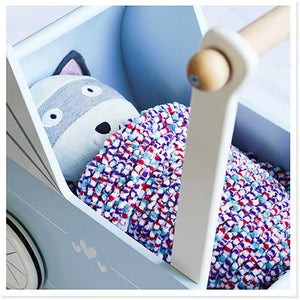 soft toy wrapped in the knitted doll's pram blanket sized to fit