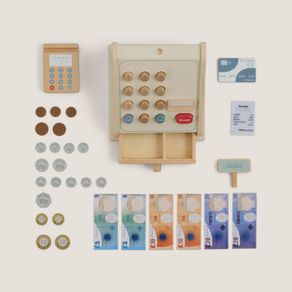Wooden toy cash register with card reader and coins on a light background
