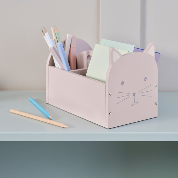 Pink cat-shaped pencil holder with stationery on a light gray surface
