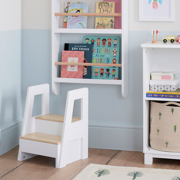 Children's step stool in a room with books and shelves.