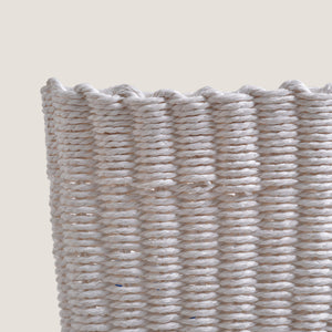 Close-up of a woven basket with a textured pattern on a beige background
