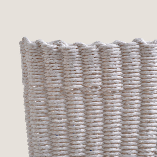 Close-up of a woven basket with a textured pattern on a beige background