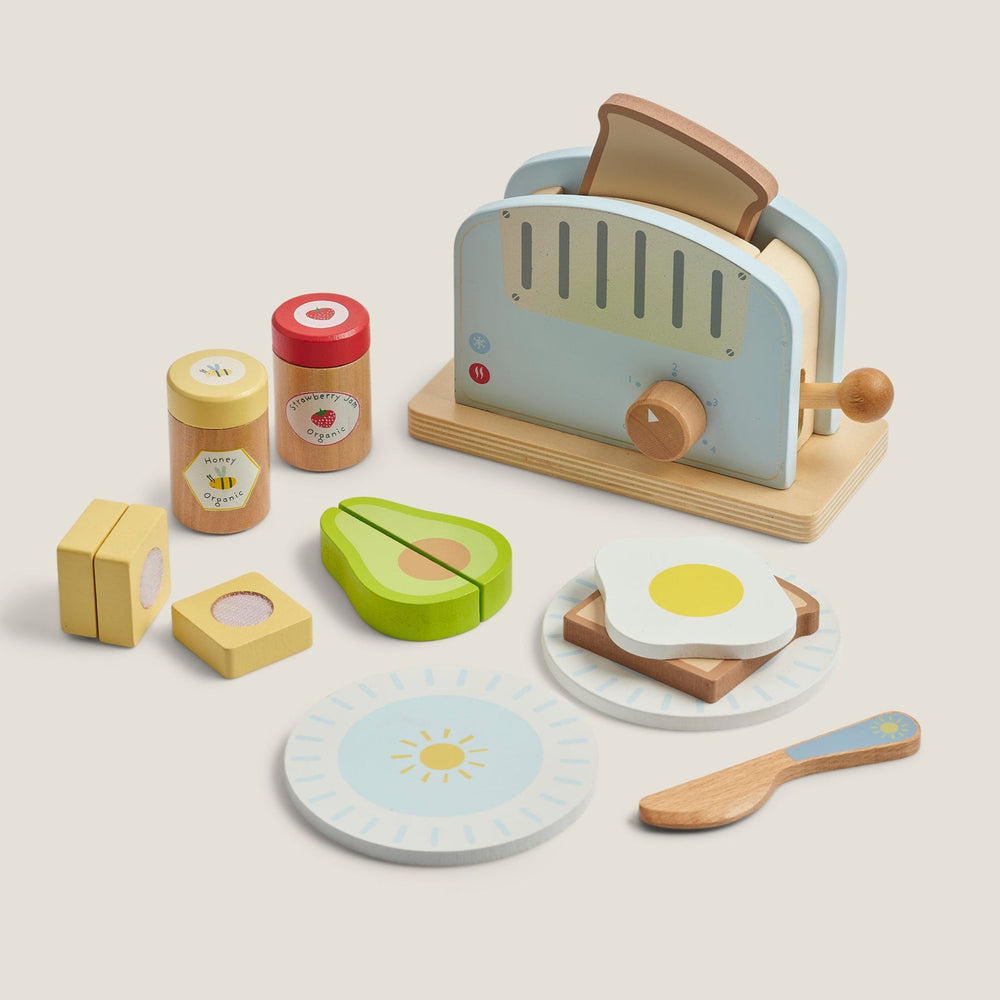 Wooden toy kitchen set with toaster, avocado, toast, and eggs on a beige background