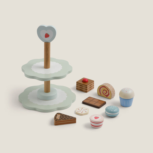 Wooden toy cake stand with various miniature food items on a light background