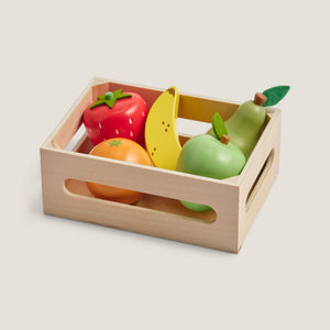 Wooden crate with toy fruits on a light background