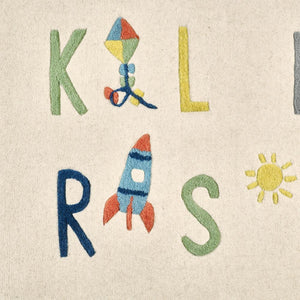 Children's rug with colorful letters and a kite design on a beige background