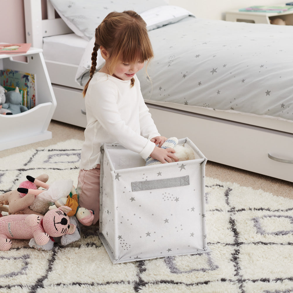 Little girl playing with a canvas storage cube