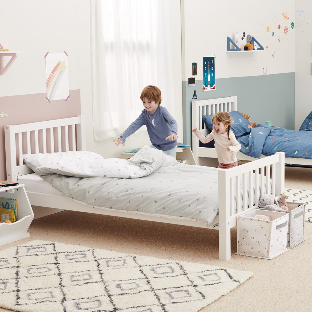 Children playing in grey stardust themed bedroom with canvas storage cubes