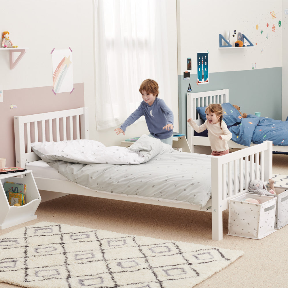 Kids playing in bedroom with grey scattered stars bedding